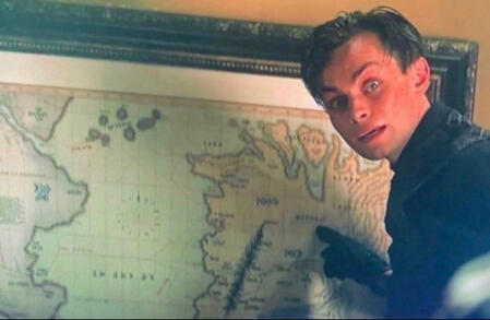 Freddy Carter as Kaz Brekker pointing at a map while talking to a ravka refugee. Season 1 Episode 2, time stamp: 14:06.
